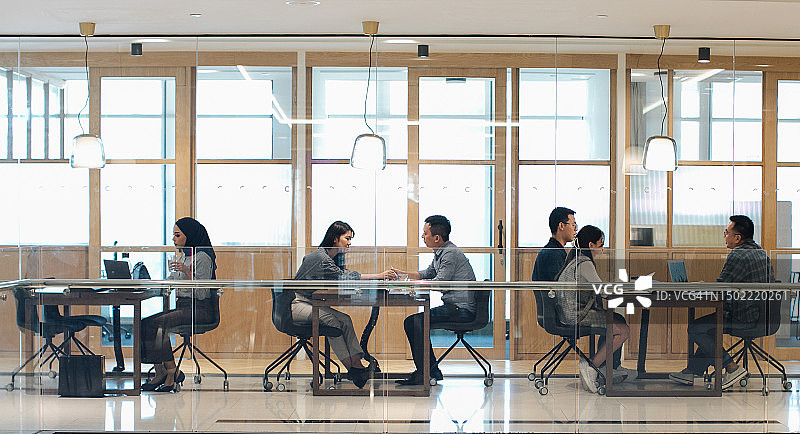 在共享开放式办公室工作的多种族亚洲人群体图片素材