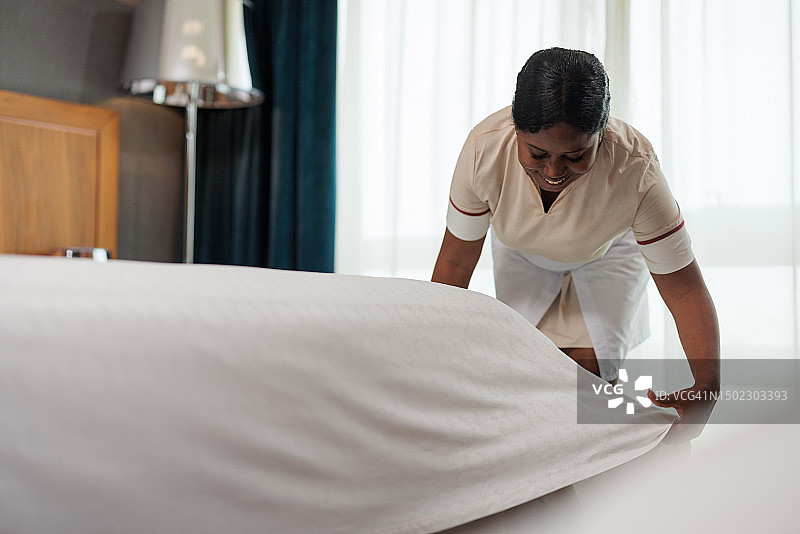 非洲裔美国女佣整理床单图片素材