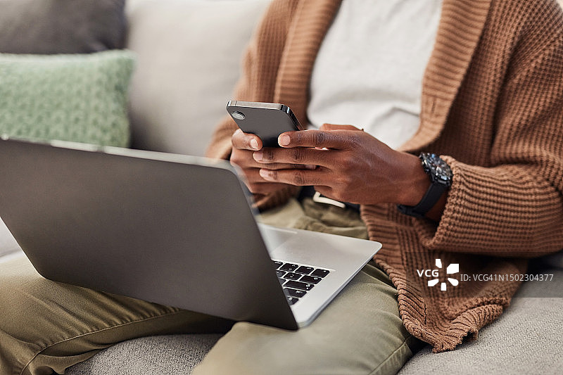 笔记本电脑、手机和在沙发上使用社交媒体的男人图片素材