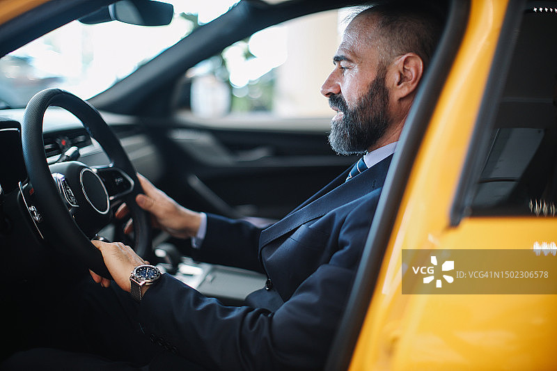 中年男子在汽车经销店展厅图片素材