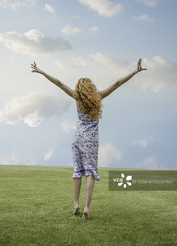 在草地上跳跃的女人图片素材