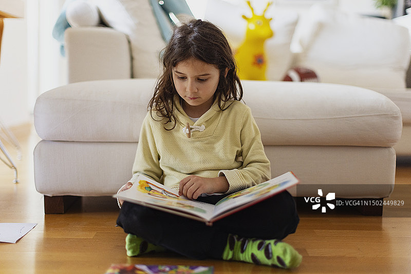 在客厅里读书的六岁男孩图片素材
