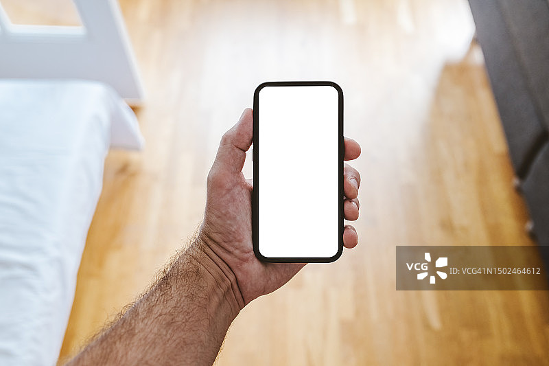 男子在瑞典家中手持手机的局部镜头图片素材