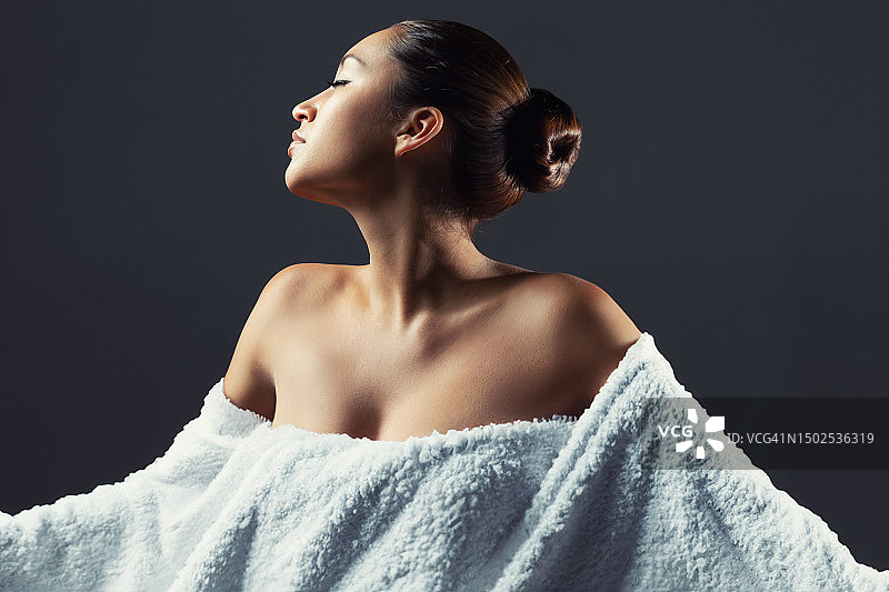 裹着大毛巾的漂亮年轻西班牙裔女人图片素材