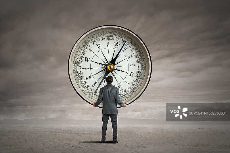 男人携带一个大型指南针图片素材