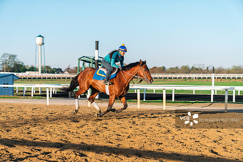 骑师在泥土赛道上训练纯种赛马图片素材