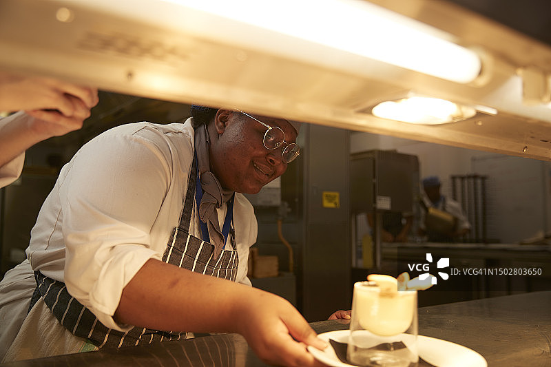 在厨房工作的微笑少年厨师图片素材