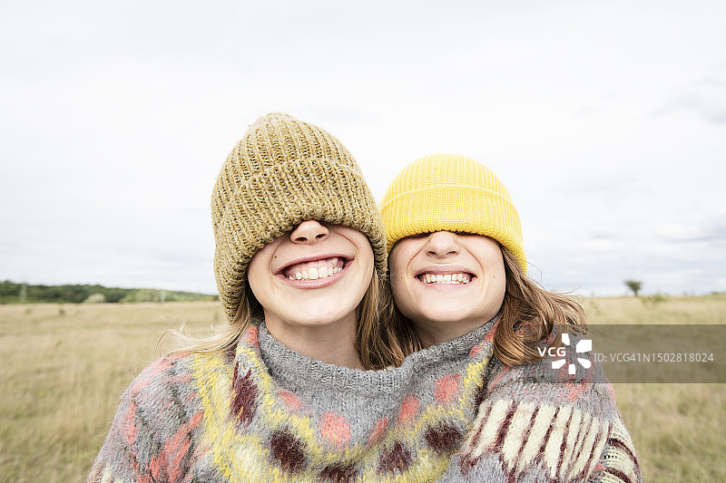 戴着无檐小便帽遮住眼睛的微笑女孩朋友图片素材