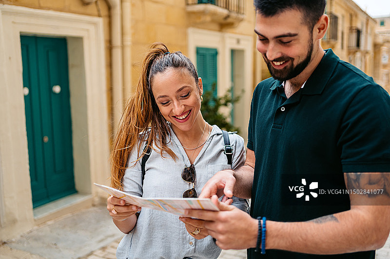 在马耳他瓦莱塔阅读地图的年轻游客情侣图片素材
