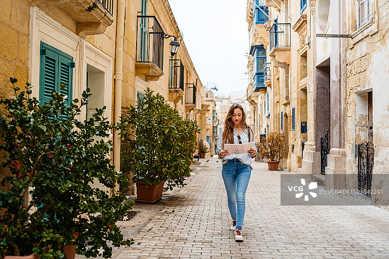 在马耳他瓦莱塔阅读地图的年轻女游客图片素材