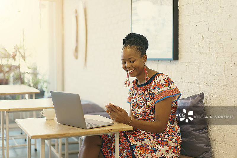 积极乐观的情绪：在创意联合办公空间远程工作的年轻非洲女商人，数字技术与成功图片素材