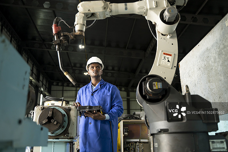机械工程师在工厂控制和输入机器人焊接参数程序图片素材