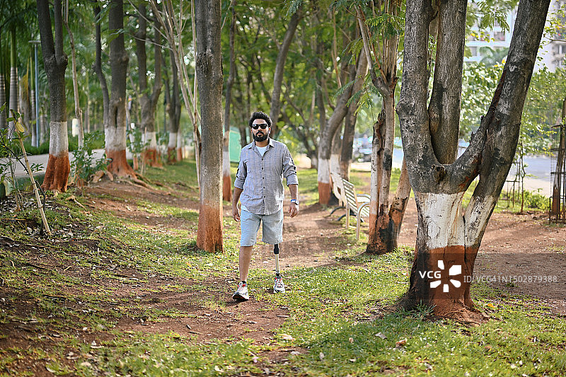 装有假肢的男人自信地走过自然中的树林图片素材
