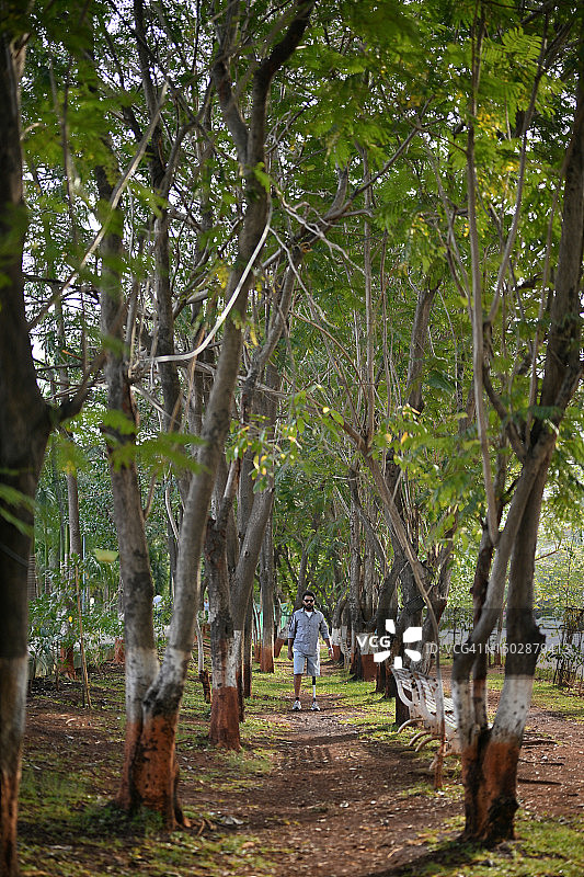 装有假肢的男人自信地走过自然中的树林图片素材