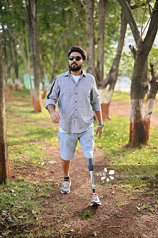 装有假肢的男人自信地走过自然中的树林图片素材