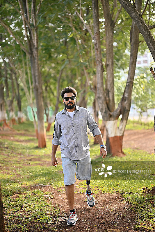 装有假肢的男人自信地走过自然中的树林图片素材