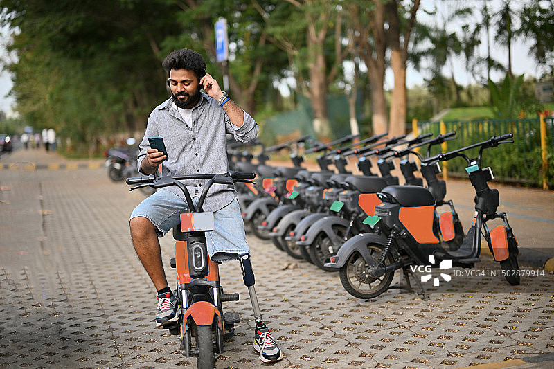 戴着假肢腿享受音乐，骑着电动自行车的男人图片素材