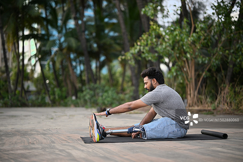 装有假肢的男人在户外进行锻炼后的伸展运动图片素材