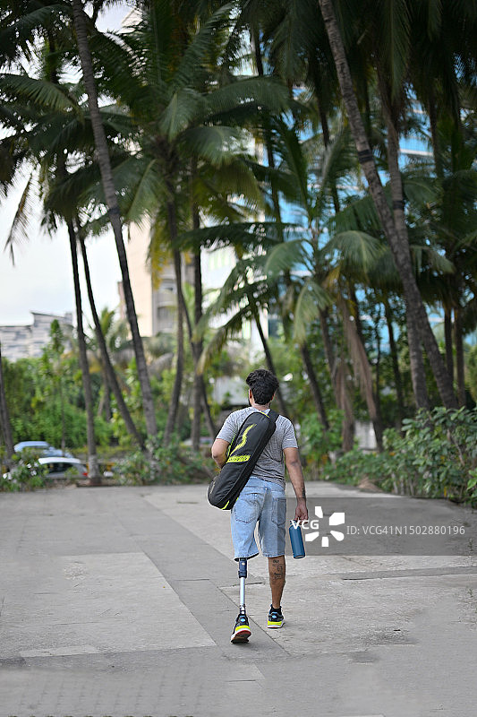 做完瑜伽回来的装有假肢的坚韧男人背影图片素材
