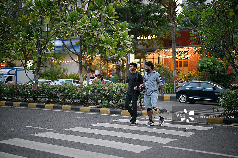 装有假肢的男人自信地和朋友一起过马路图片素材