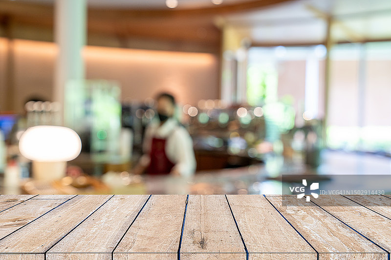 咖啡店人群模糊背景下的木制桌面图片素材
