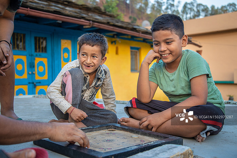 印度乡村学校的孩子们玩卡罗姆棋盘图片素材