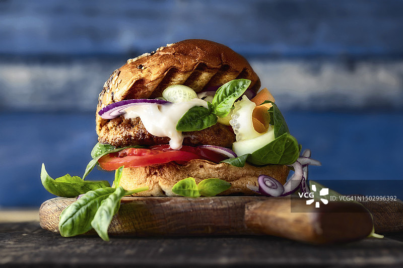 木板上的牛肉汉堡配蔬菜和酸奶，健康食品图片素材