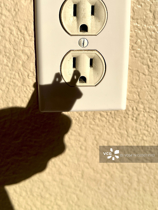 手将插头插入墙壁插座的阴影 II图片素材