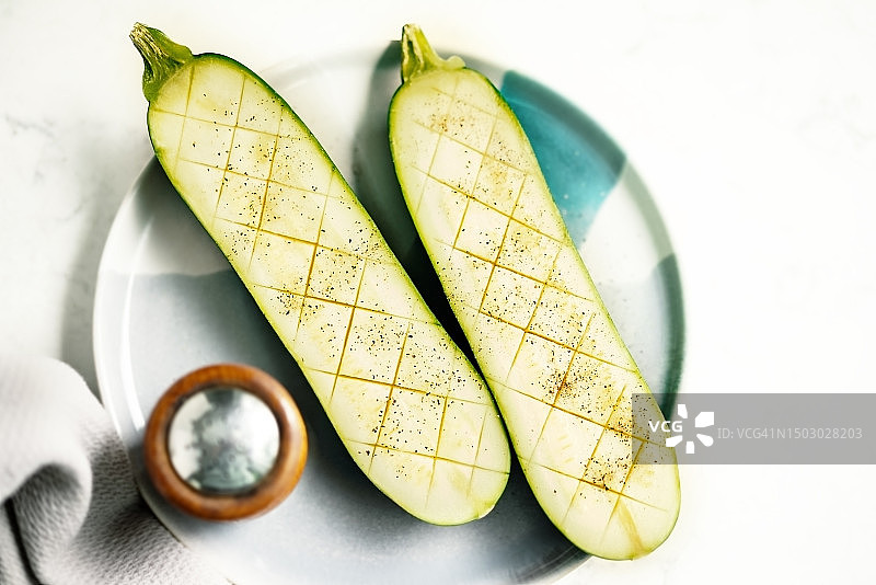 白色背景盘子上的半个生西葫芦图片素材