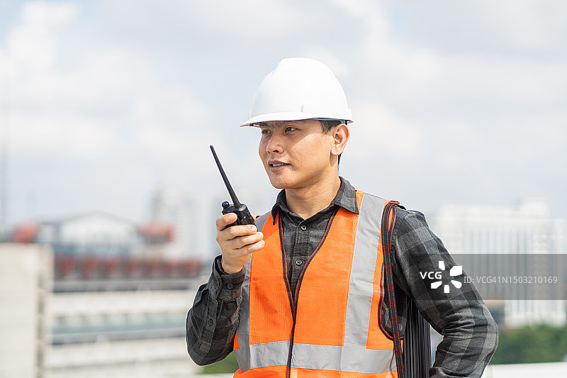 手持对讲机的亚洲青年工程师肖像图片素材