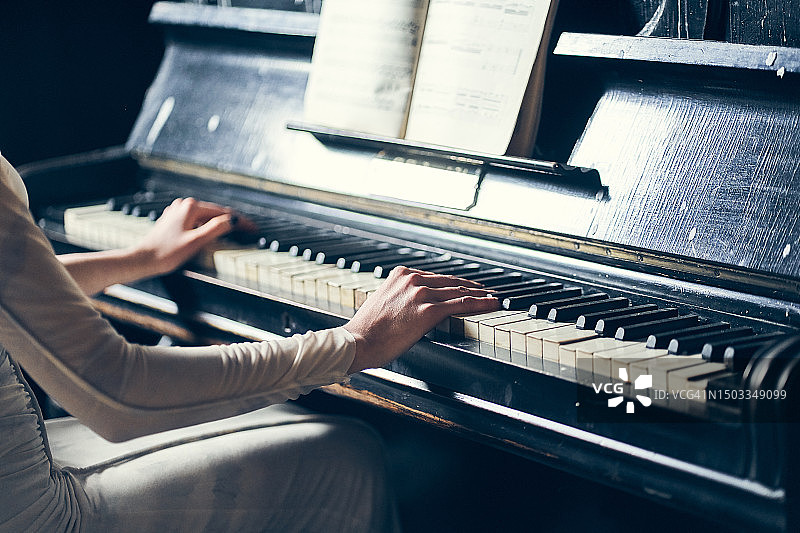 弹钢琴的女人。最喜欢的爱好，学习如何在键盘乐器上演奏音乐的概念，带有复制空间的特写海报。图片素材