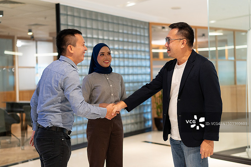 亚洲多民族员工热情地握手欢迎客人图片素材