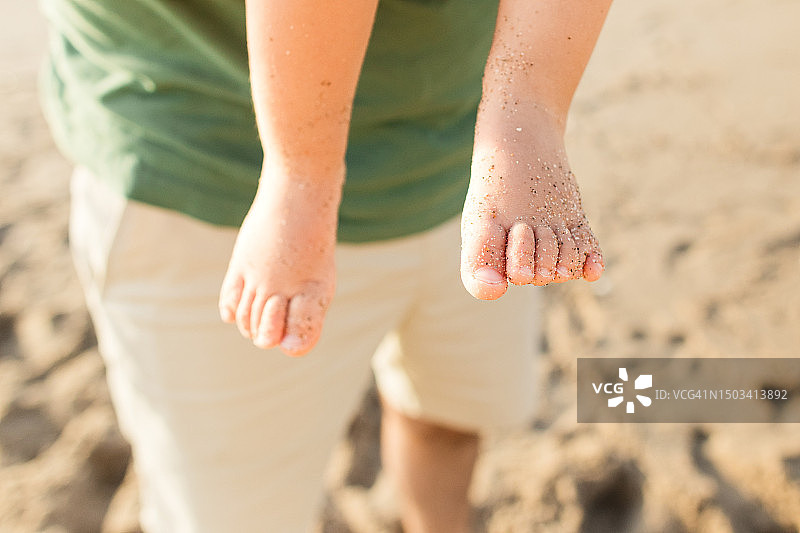 2023年夏季，在佛罗里达州棕榈滩金色日出时，一位父亲抱着他1岁的古巴裔美国男婴，男婴的脚有12个脚趾（轴后多指畸形）图片素材