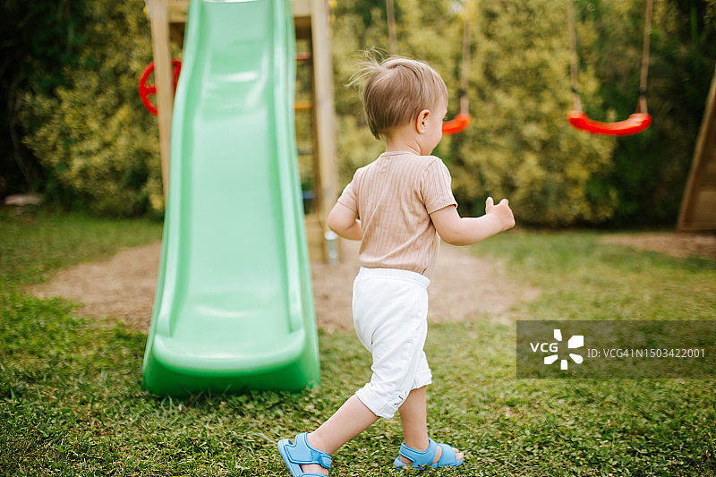 男孩在公园的滑梯上玩耍图片素材