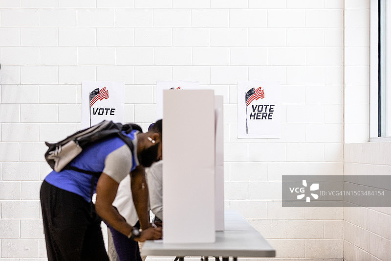 男性选民在隐私隔间填写选票图片素材