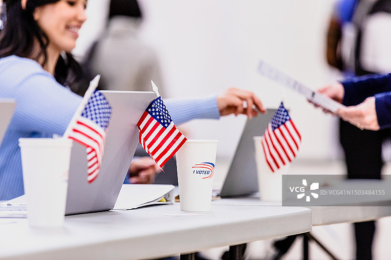 选举期间在电脑前工作的微笑年轻女子图片素材