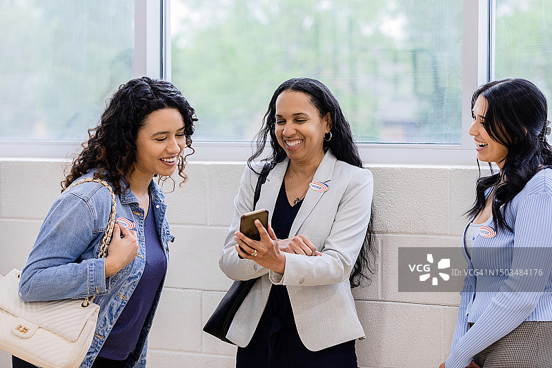 等待团队成员时欢笑交谈的商务女人图片素材