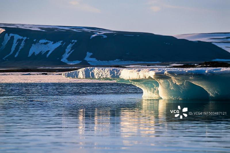 挪威斯瓦尔巴特群岛海岸午夜阳光下的融冰图片素材