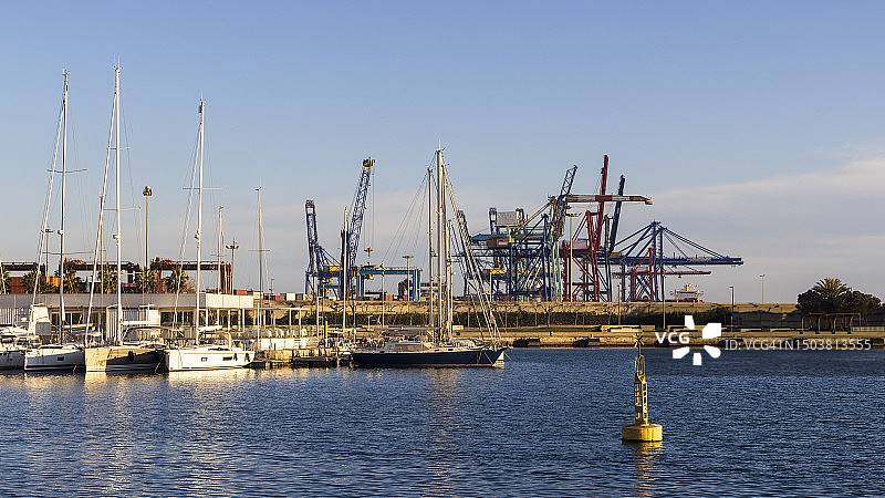 西班牙瓦伦西亚：停泊在码头的帆船，背景是码头起重机图片素材
