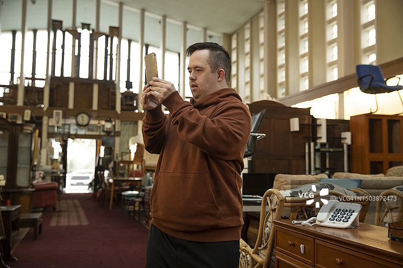 唐氏综合征工人在家具店使用电话图片素材