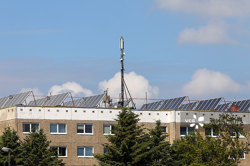 住宅楼顶的手机发射天线和太阳能电池板图片素材