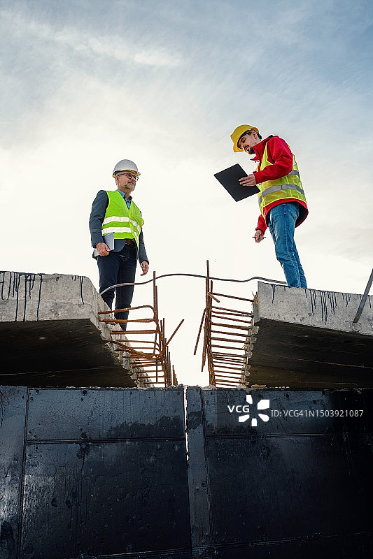 工程师与投资者在道路施工现场图片素材