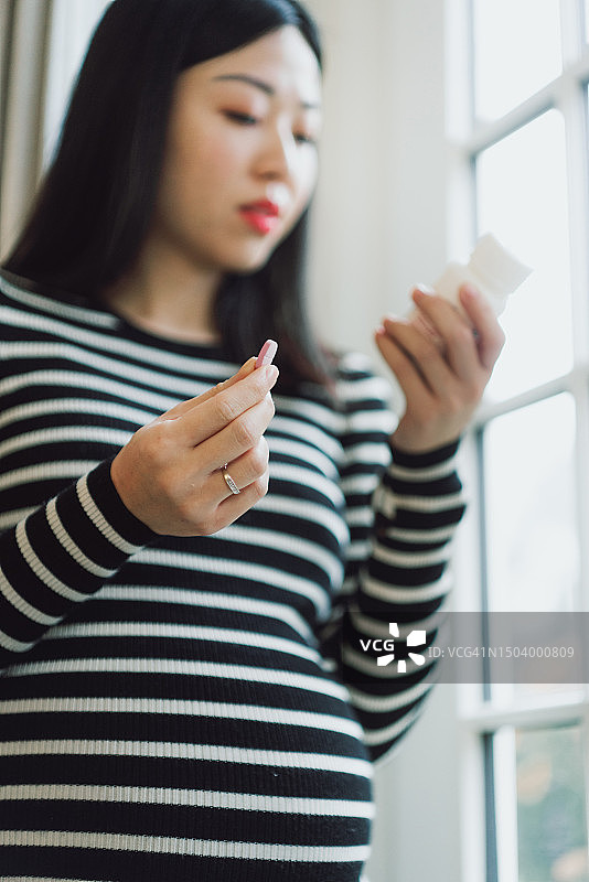 孕妇在家服用补剂药丸图片素材