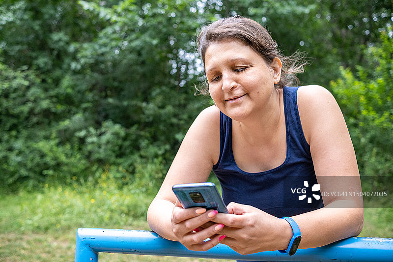 身穿运动服的年轻女子正在看手机图片素材