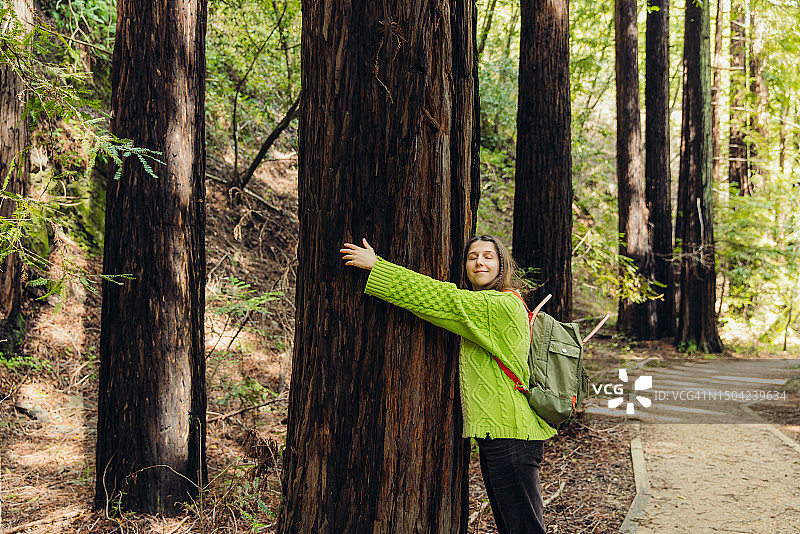 女子在红杉林中沉思自然之美图片素材
