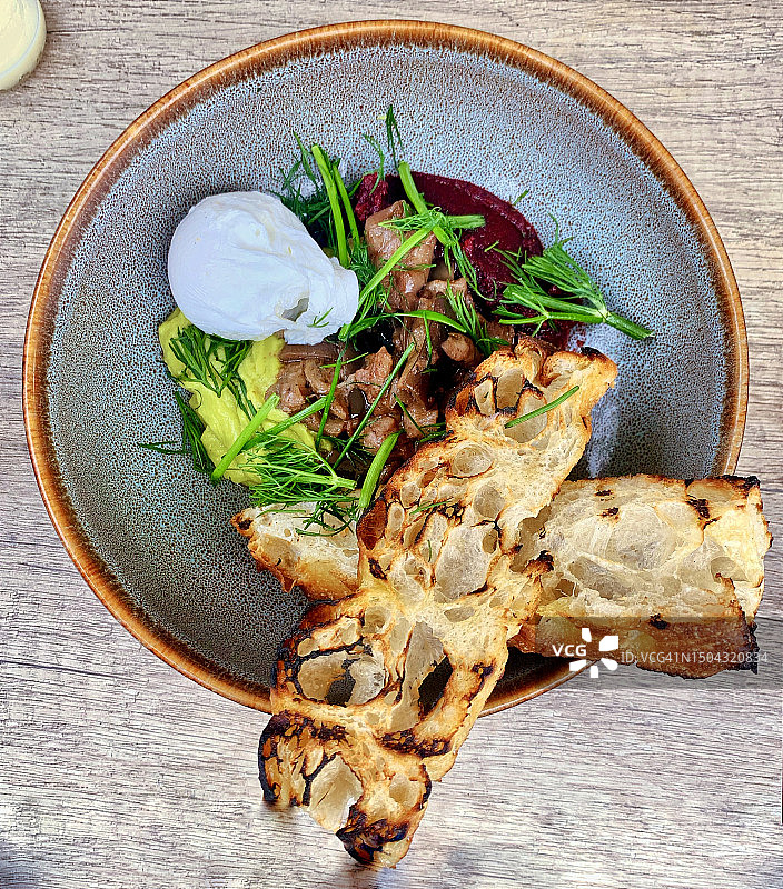 牛油果蘑菇早餐：搭配手工酸面包，摆放在伦敦时尚小酒馆的陶瓷盘中图片素材