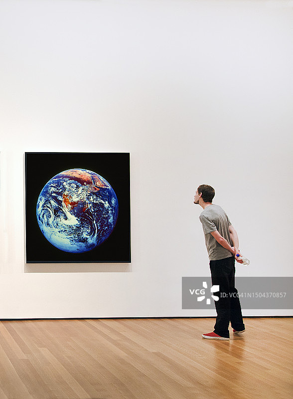 青年男人看着地球照片图片素材