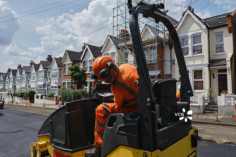 道路铺设：工人驾驶沥青机图片素材