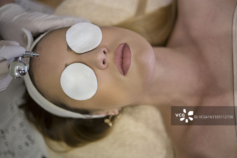 美容师为美丽女性进行面部注氧护理图片素材