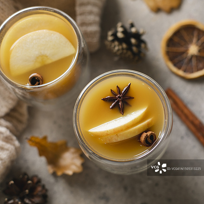 玻璃杯装热苹果酒配肉桂棒和八角图片素材